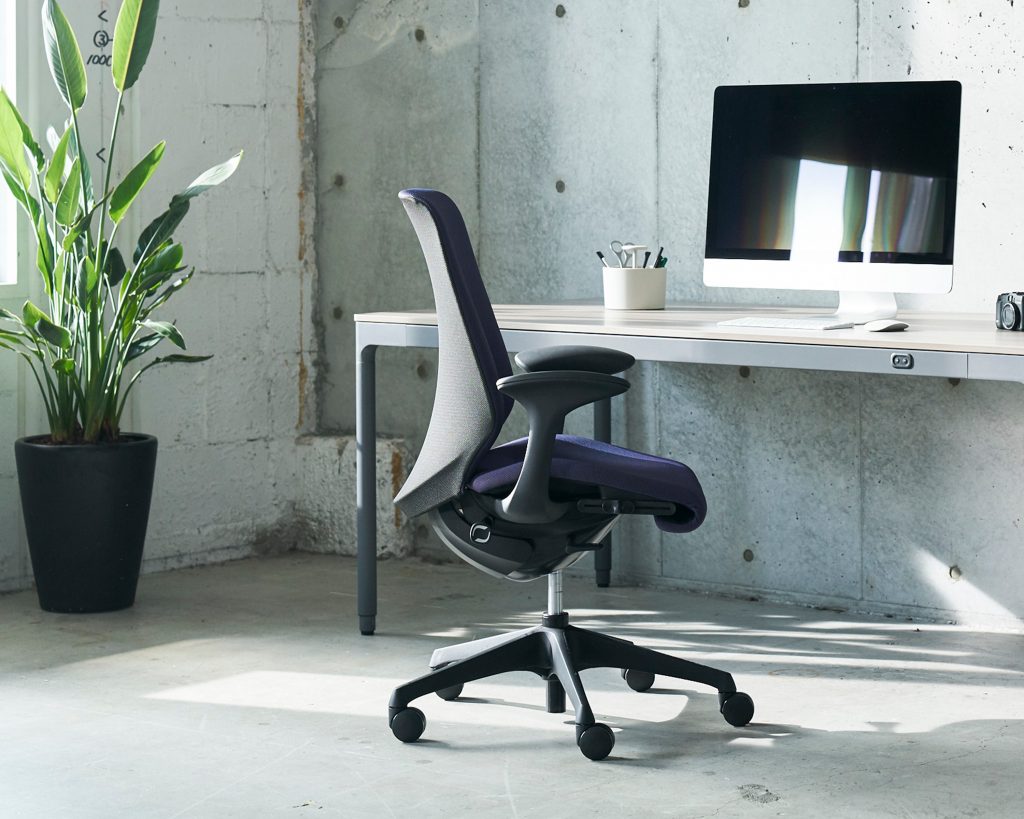 blue chair facing a workstation in a sun lit room